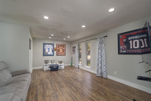 living room featuring dark hardwood / wood-style floors and a textured ceiling