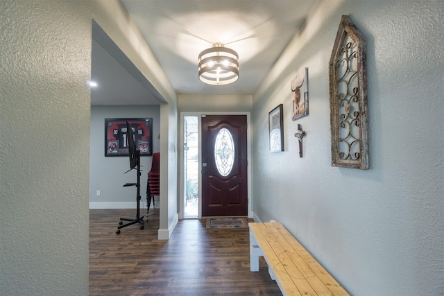 foyer entrance featuring dark hardwood / wood-style floors and a notable chandelier