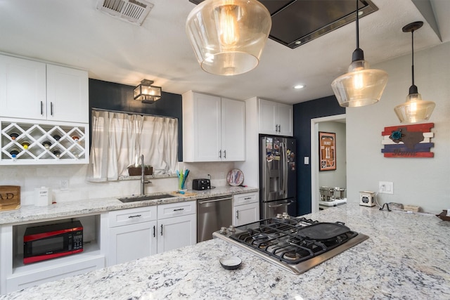 kitchen featuring sink, white cabinetry, light stone counters, hanging light fixtures, and appliances with stainless steel finishes