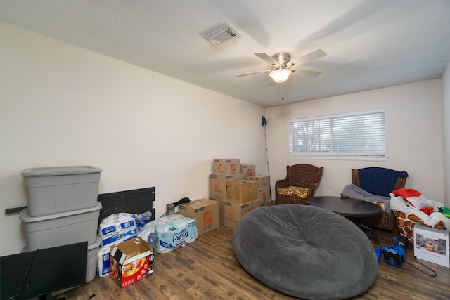 living area featuring hardwood / wood-style floors and ceiling fan