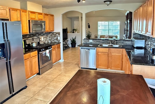 kitchen with tasteful backsplash, sink, light tile patterned floors, and stainless steel appliances