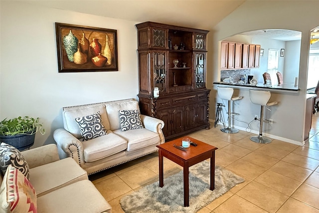 living room featuring lofted ceiling and light tile patterned floors