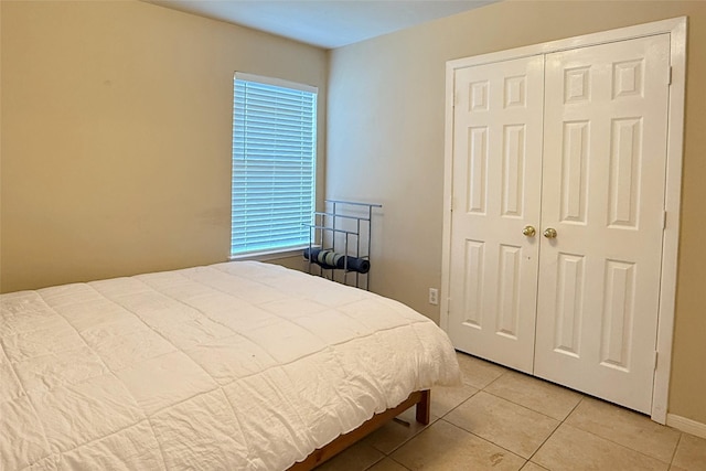 bedroom with light tile patterned floors and a closet