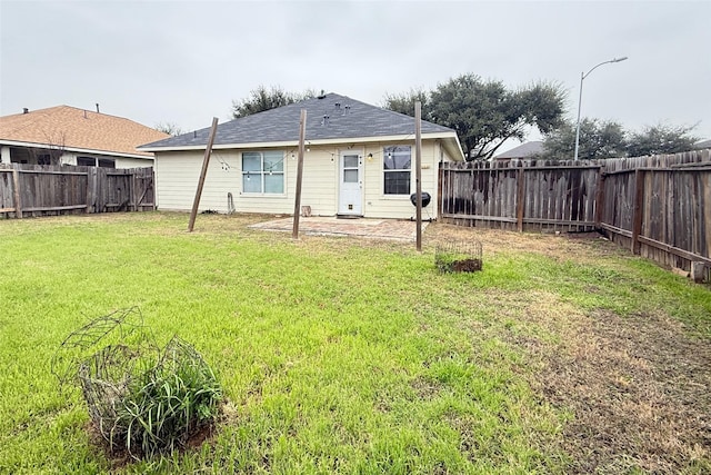 rear view of house featuring a yard and a patio area