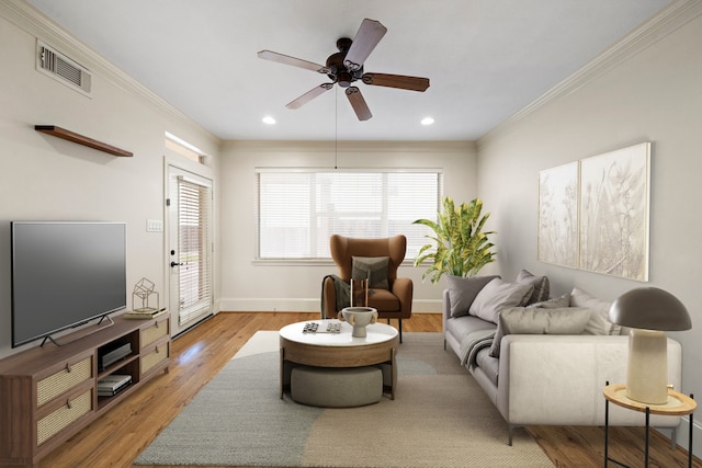 living room featuring crown molding, ceiling fan, and light wood-type flooring