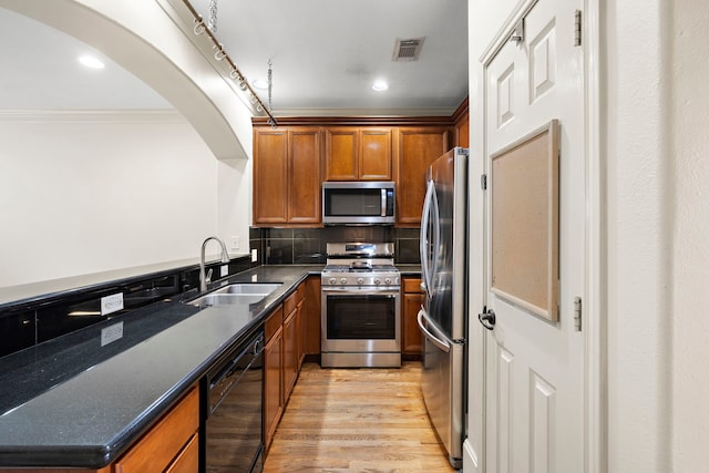 kitchen with sink, tasteful backsplash, light wood-type flooring, ornamental molding, and stainless steel appliances