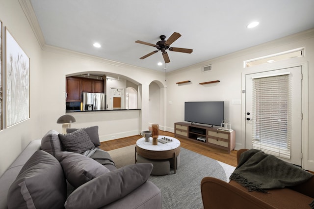 living room featuring ornamental molding, hardwood / wood-style floors, and ceiling fan