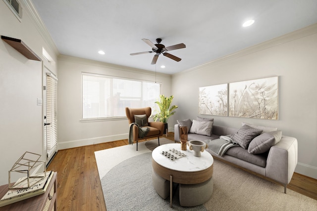 living room featuring crown molding, wood-type flooring, and ceiling fan