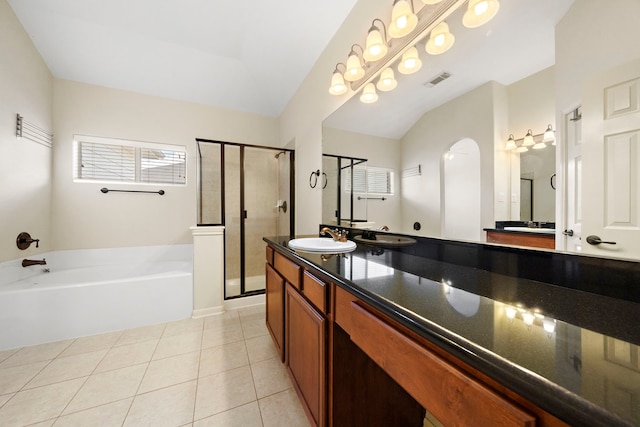 bathroom featuring vaulted ceiling, vanity, shower with separate bathtub, and tile patterned flooring