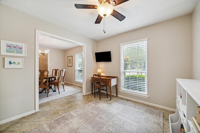 office area featuring ceiling fan with notable chandelier, a wealth of natural light, and a textured ceiling