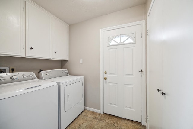 clothes washing area featuring washer and dryer and cabinets