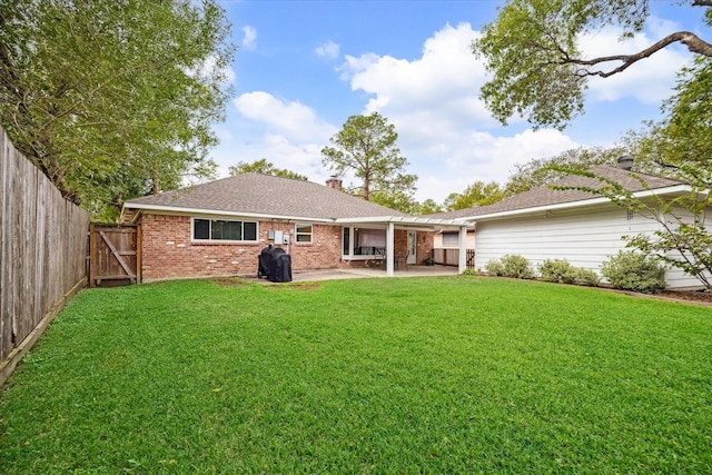 rear view of property with a patio and a yard