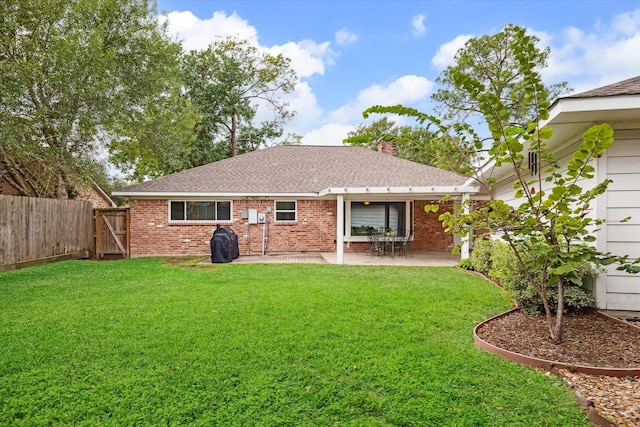 back of property with a yard and a patio