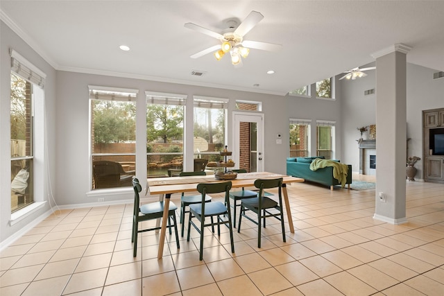 tiled dining space featuring ceiling fan and ornamental molding