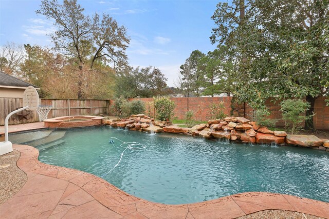 view of swimming pool featuring pool water feature and an in ground hot tub