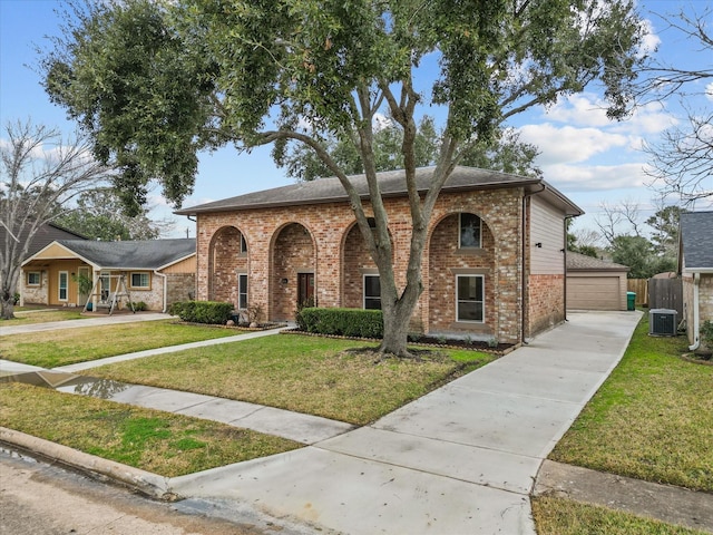 view of front of house with a garage, cooling unit, and a front yard