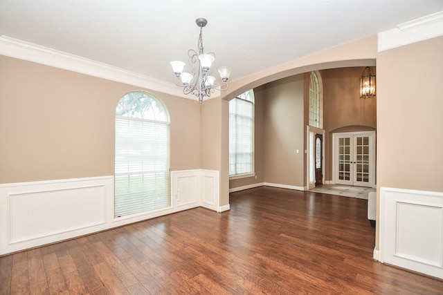 spare room featuring crown molding, a notable chandelier, dark hardwood / wood-style flooring, and french doors