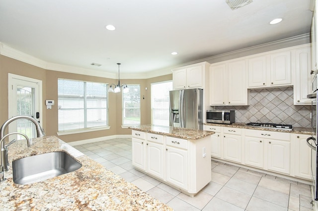 kitchen with stainless steel appliances, sink, pendant lighting, and white cabinets