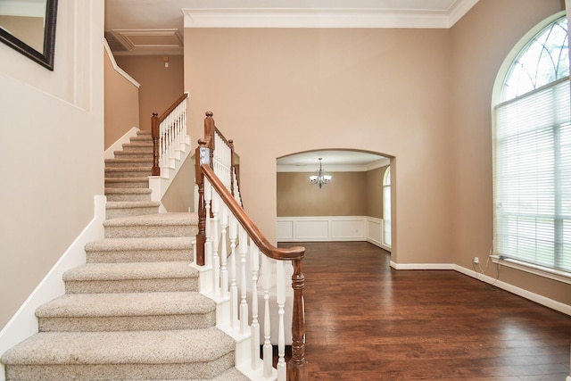 stairway with hardwood / wood-style floors and crown molding