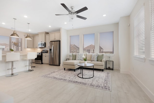 living room featuring light hardwood / wood-style floors and ceiling fan