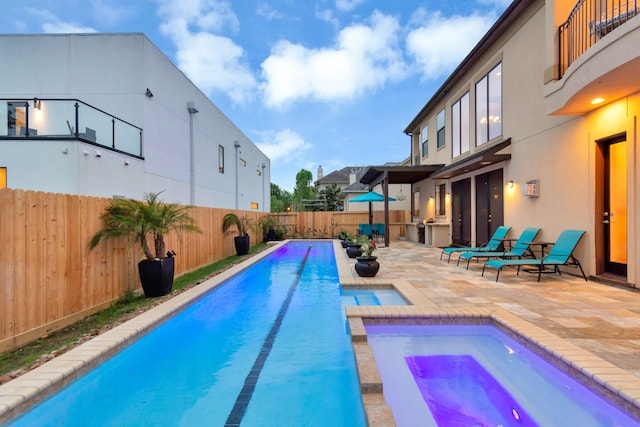 view of pool with a patio area, area for grilling, and an in ground hot tub