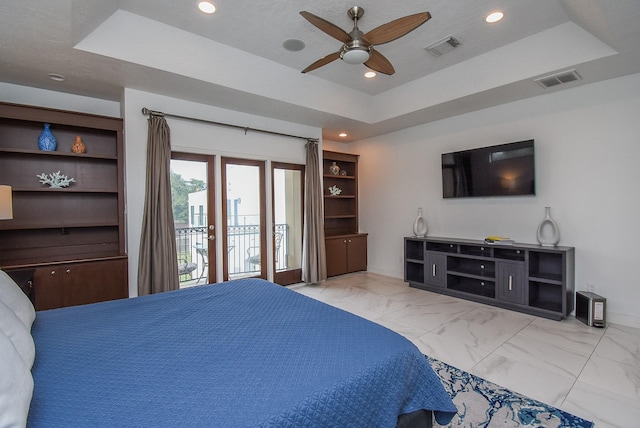 bedroom with a tray ceiling, access to exterior, and ceiling fan