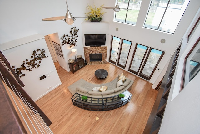 living room featuring hardwood / wood-style flooring, a premium fireplace, and a high ceiling