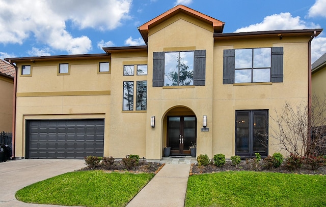 view of front of house featuring french doors, a front yard, and a garage