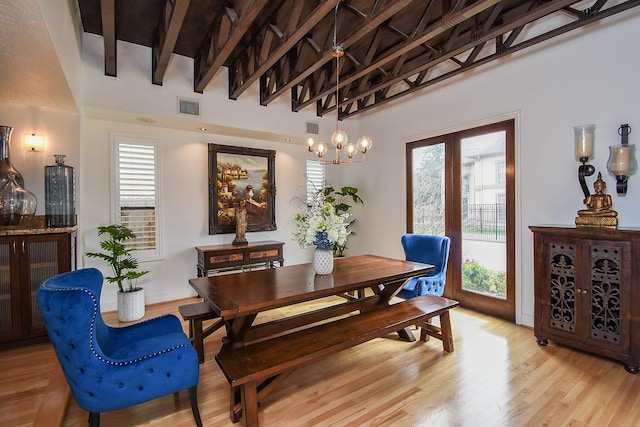 dining room with plenty of natural light, light hardwood / wood-style floors, and beamed ceiling