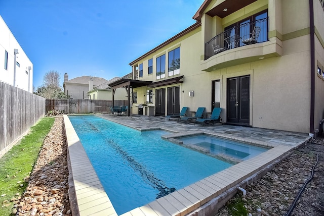 view of swimming pool featuring a patio area and an in ground hot tub