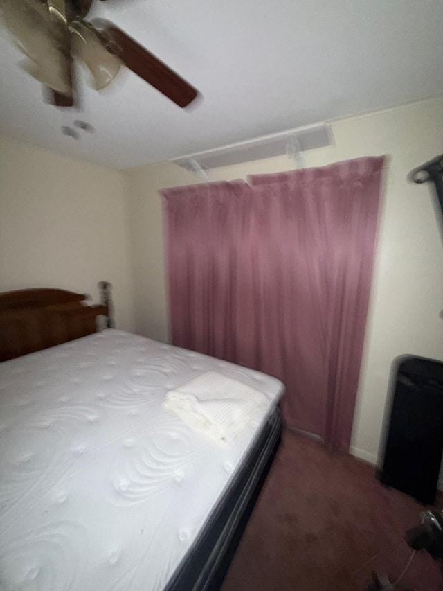 bedroom with dark colored carpet and ceiling fan