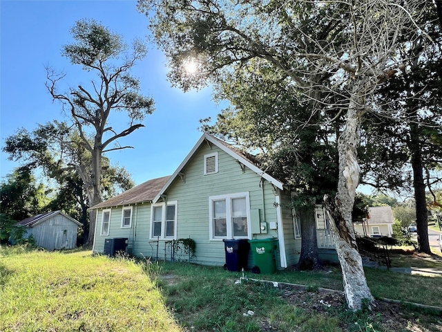 view of property exterior featuring central AC and a storage shed