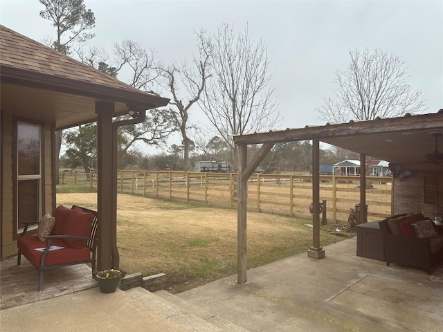 view of yard featuring a rural view, a patio, and fence