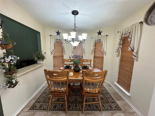 dining room with a textured ceiling, baseboards, and a notable chandelier