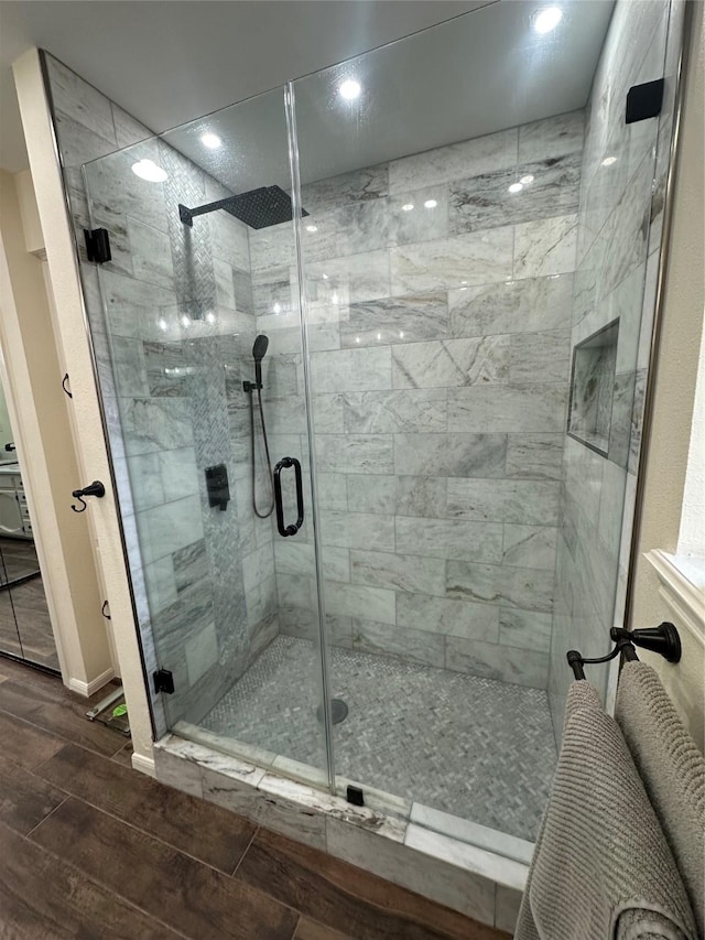 bathroom with wood finish floors and a stall shower