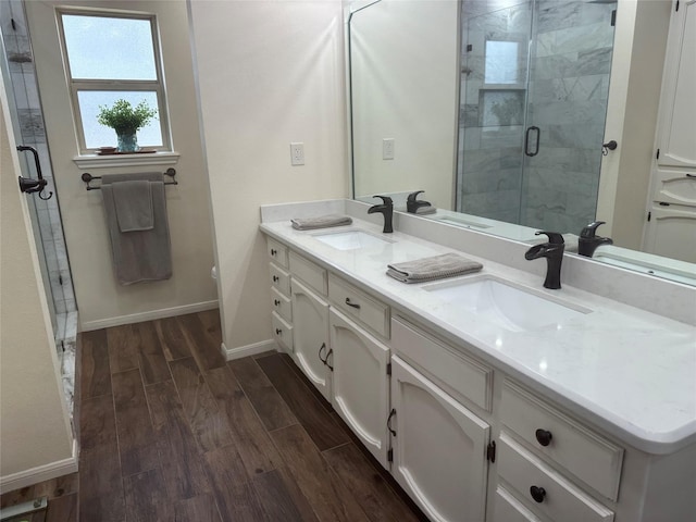 full bath featuring a shower stall, a sink, and wood tiled floor