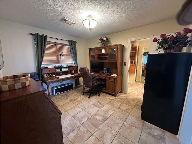 office with visible vents, a textured ceiling, and light tile patterned flooring