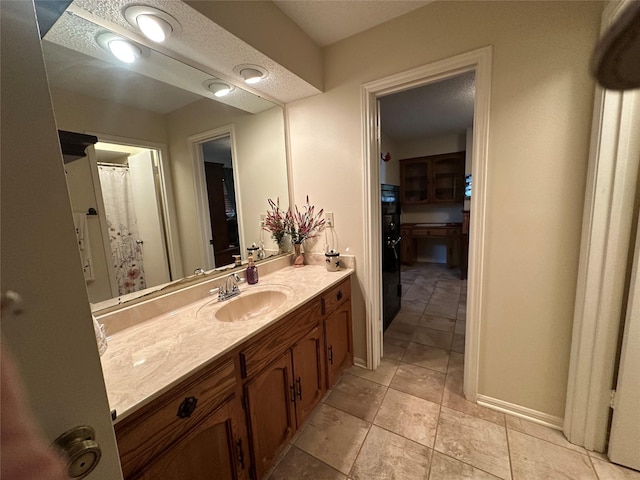 full bath featuring baseboards and vanity