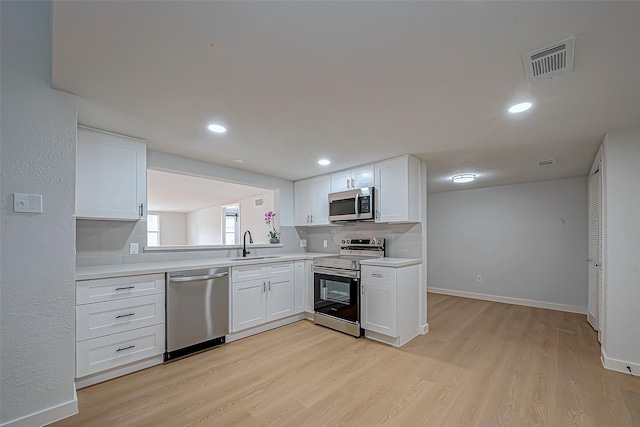 kitchen featuring sink, stainless steel appliances, light hardwood / wood-style floors, and white cabinets