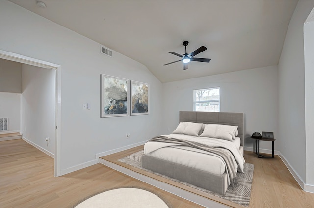 bedroom with light hardwood / wood-style flooring, vaulted ceiling, and ceiling fan