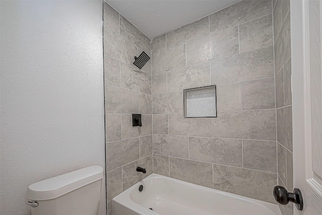 bathroom featuring tiled shower / bath and toilet