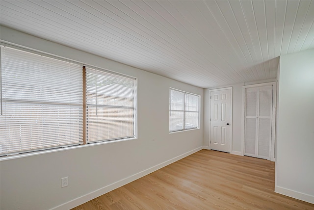 empty room featuring wood ceiling and light hardwood / wood-style flooring