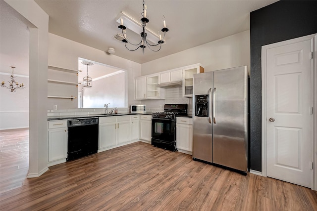 kitchen with white cabinets, pendant lighting, a notable chandelier, and black appliances