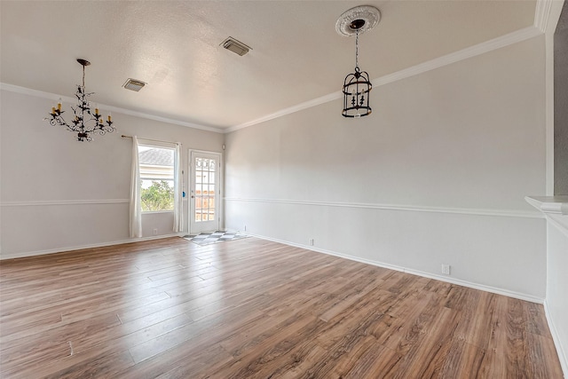 unfurnished room featuring a notable chandelier, ornamental molding, and light wood-type flooring