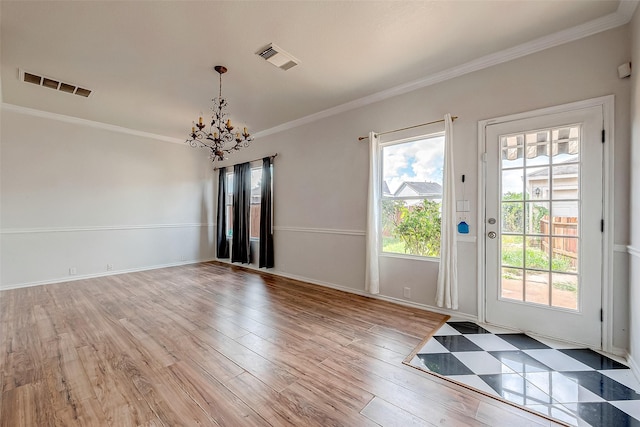 interior space with an inviting chandelier, ornamental molding, and light wood-type flooring