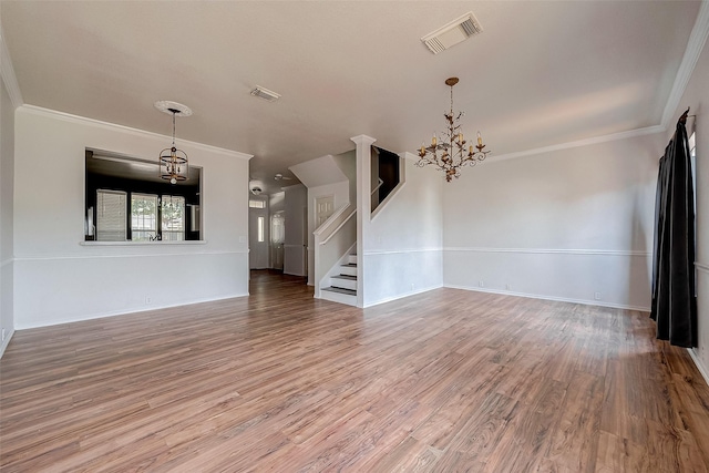 unfurnished living room with hardwood / wood-style flooring, crown molding, and a notable chandelier