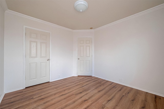 empty room featuring hardwood / wood-style flooring and ornamental molding