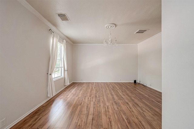 unfurnished room with ornamental molding, hardwood / wood-style floors, and a notable chandelier