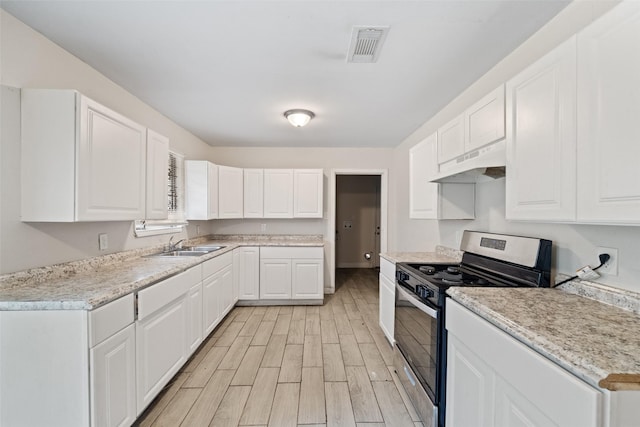 kitchen featuring gas range, sink, and white cabinets