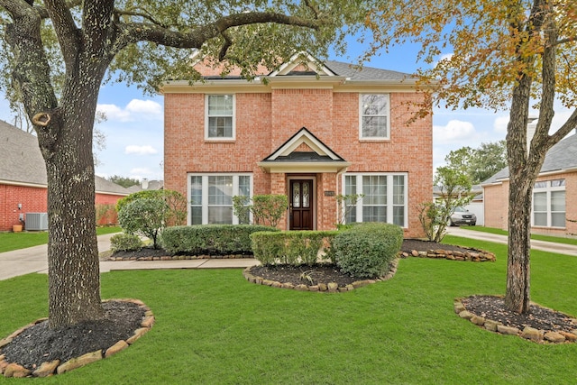 view of front facade featuring brick siding, a front lawn, and central AC unit